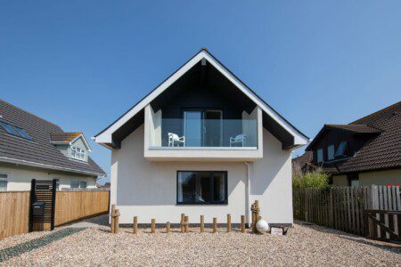 Exterior of seaside apartment in East Wittering, featuring modern architecture and a balcony
